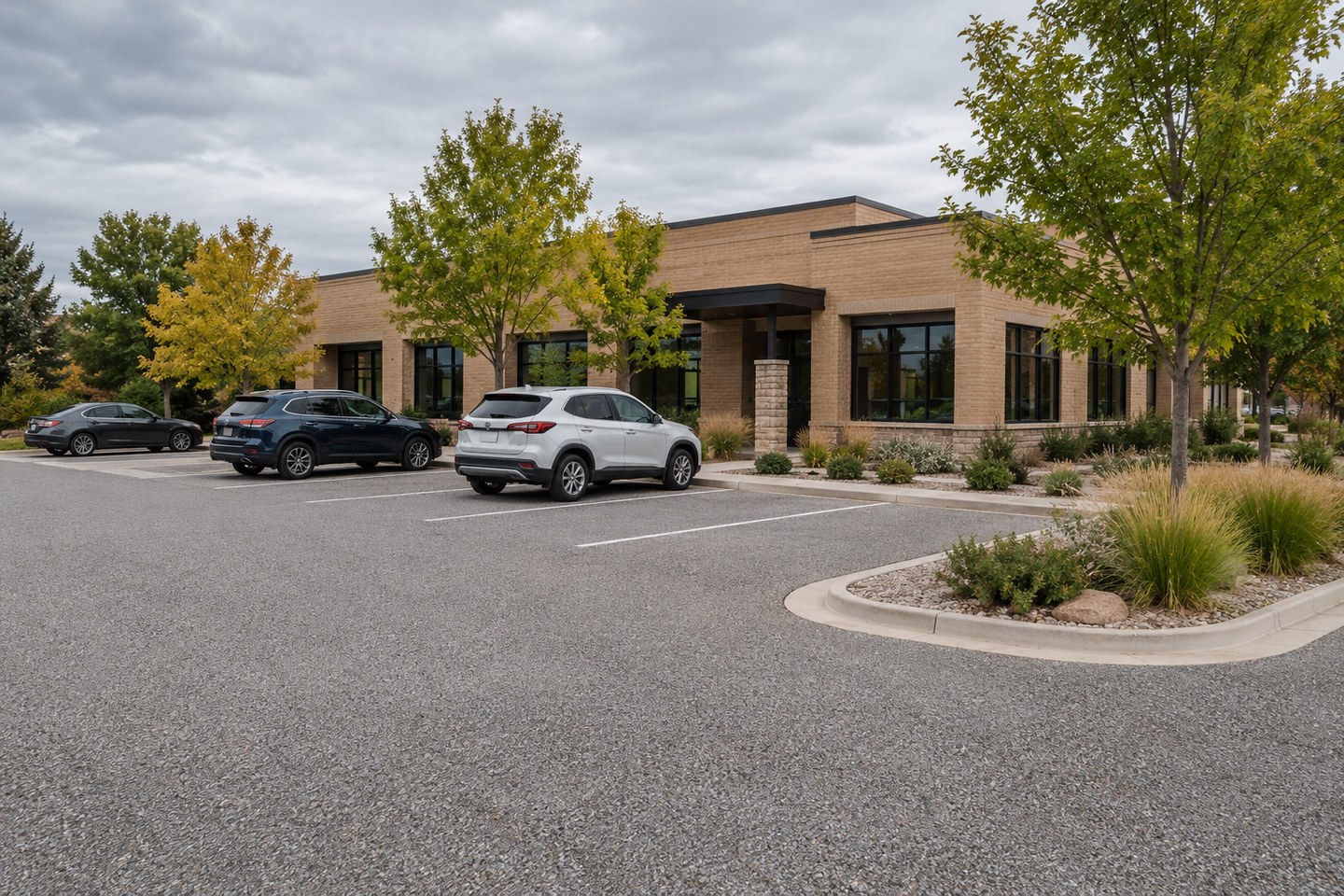 Design visualization of gray resin-bound commercial parking area with marked stalls in Fort Collins, wide view